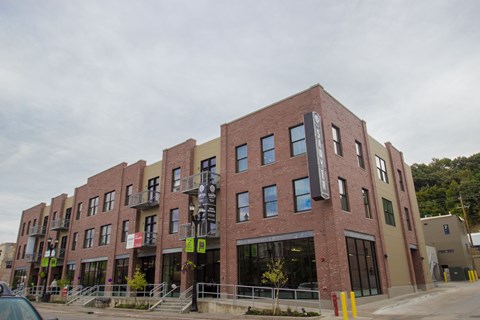 A multi-story building with a red brick facade and a green awning.
